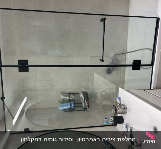 מקלחון זכוכית עם מדף מוצרים וסבונים
